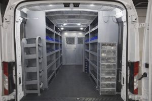 Interiör av en vit arbetsbil med professionell hyllinredning i metall.